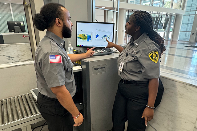 Two Security Guards Reviewing X-ray Monitor in Houston, TX Office