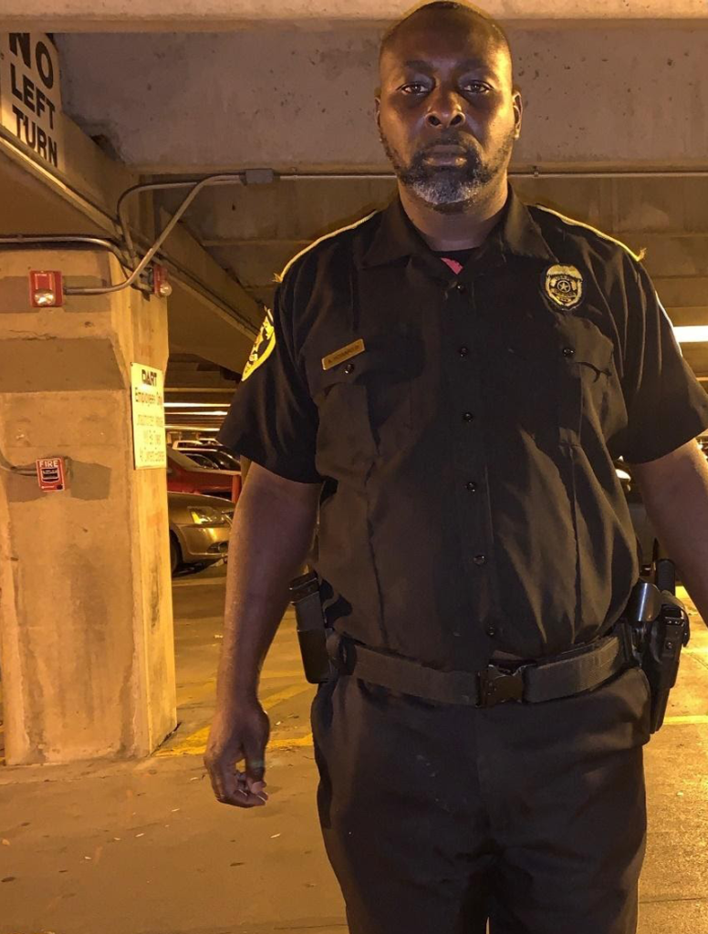 Armed Security Guard Standing in a Dimly Lit Parking Garage